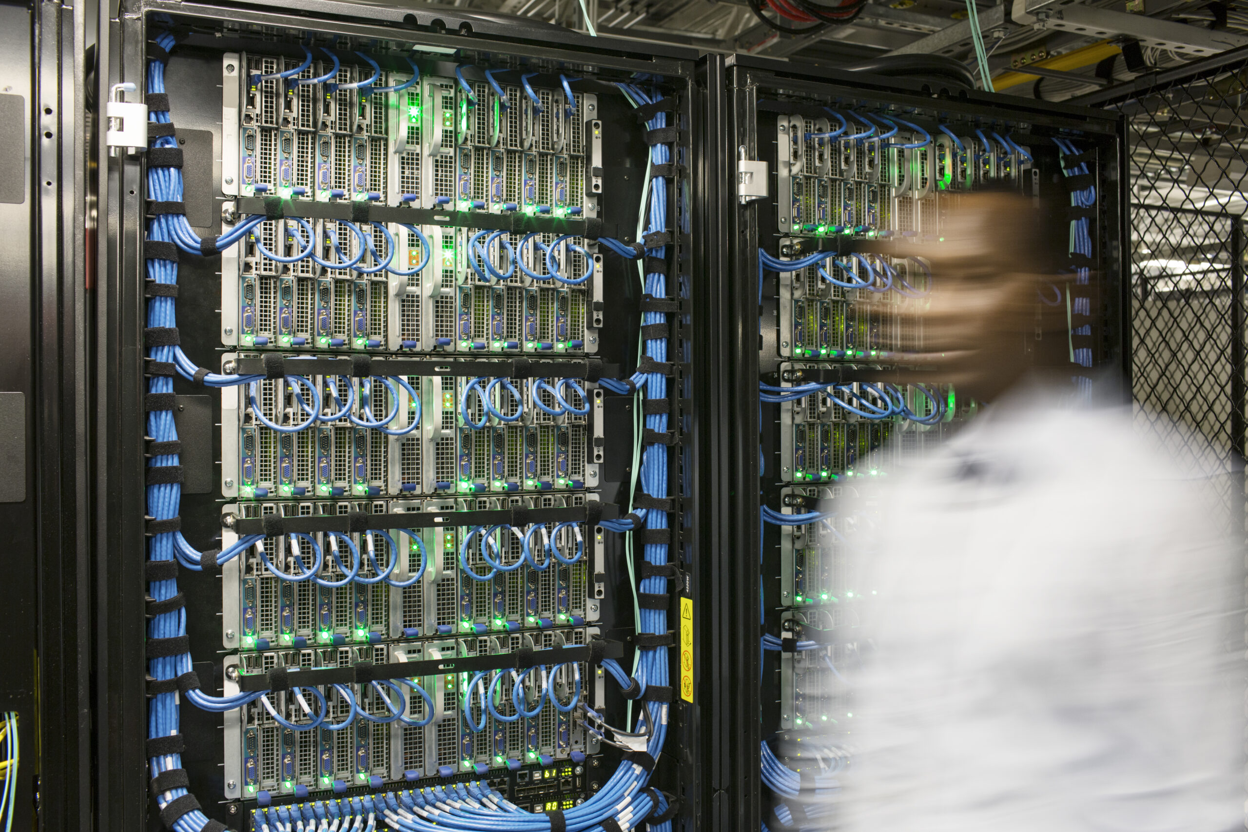 Black man technician doing diagnostic tests  on computer servers in server farm.